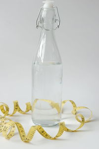 Close-up of drinking glass on table against white background