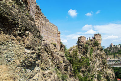 Low angle view of rock formation on mountain against sky