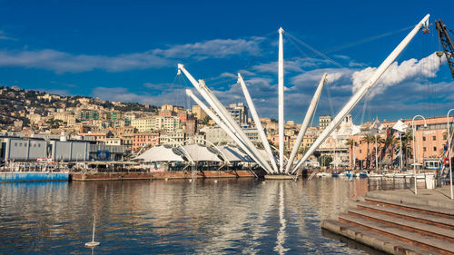 Bridge over river in city against sky