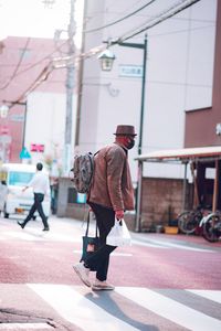 Rear view of men walking on street in city