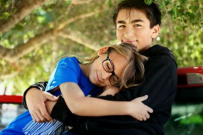 Midsection of two embracing teenagers