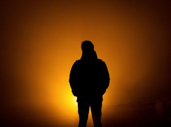 Silhouette man standing against sky during sunset