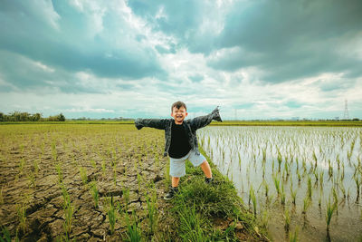 A boy who was playing in the rice field happily