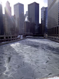 Modern buildings in city against sky during winter