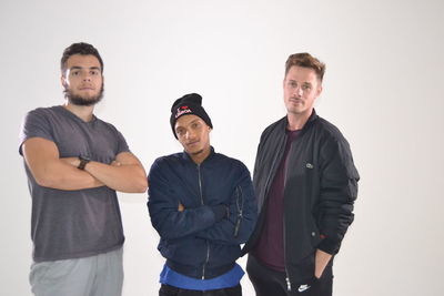 Portrait of friends standing against white background