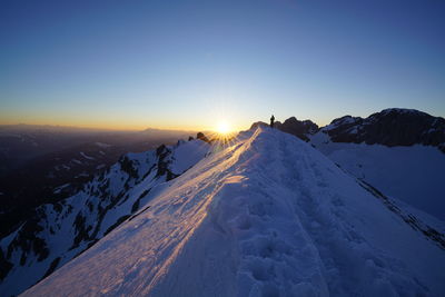 Scenic view of snow covered mountains against clear sky