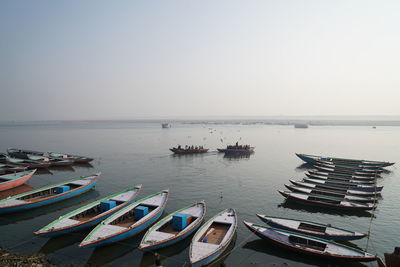 Boats moored in sea against clear sky