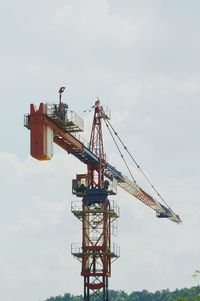 Low angle view of crane against sky