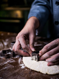 Cropped preparing cookies at table