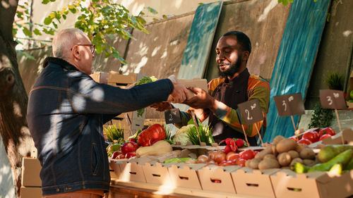 Side view of young woman holding food at market