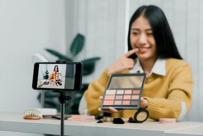 Woman using smart phone while standing on table