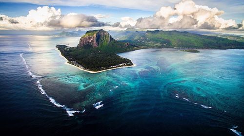 Scenic view of island amidst sea against sky