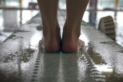 Low section of man standing on diving platform