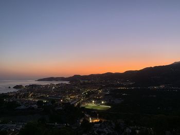 High angle view of illuminated cityscape against sky during sunset