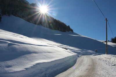 Scenic view of snow covered mountains against sky on sunny day