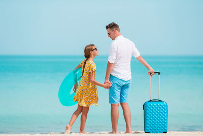 Father and daughter standing on beach