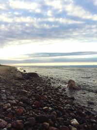 Pebbles on beach against sky