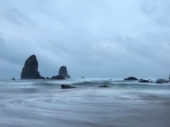 Scenic view of rocks in sea against sky