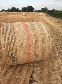 Hay bales on field against sky