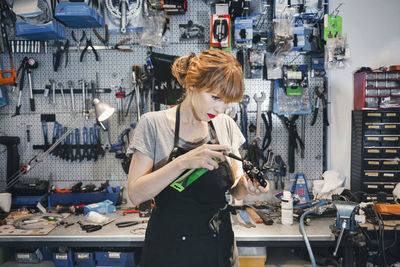 Female mechanic repairing pedal in workshop