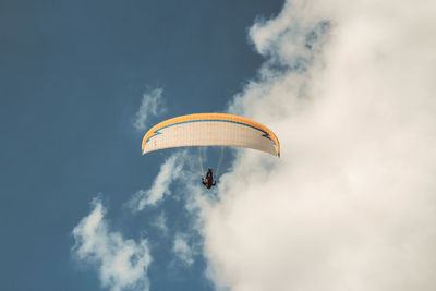 Low angle view of person paragliding in sky