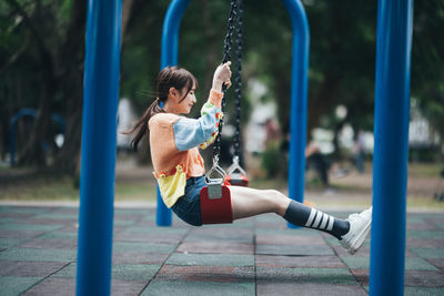 Young woman swinging at playground