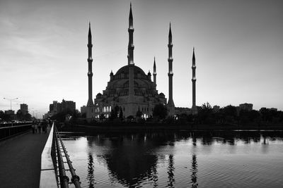 Mosque in front of lake reflection against sky