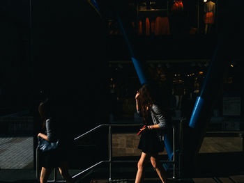 Rear view of woman standing on staircase