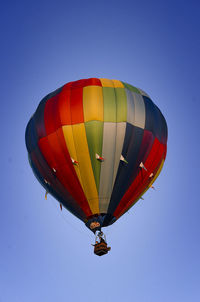 Low angle view of hot air balloon against clear blue sky