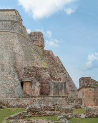 Low angle view of old building against cloudy sky