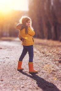 Full length of smiling girl standing outdoors