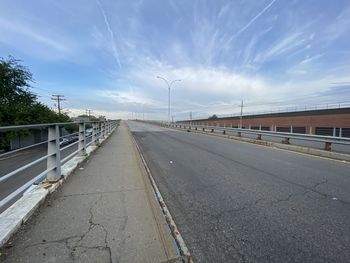 Empty road against sky in city