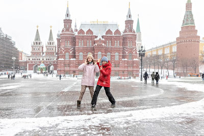 Full length of people on snow covered city during winter