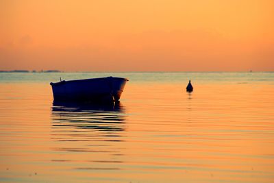 Boat in sea against sky during sunset