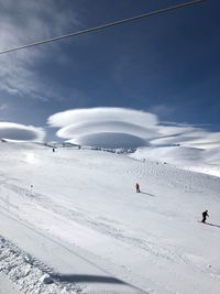 People skiing on snowcapped mountain against sky