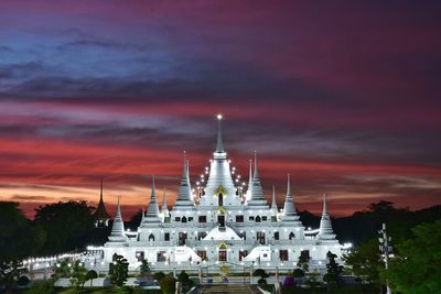 Panoramic view of illuminated building against sky during sunset