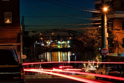 Light trails on road in front of river