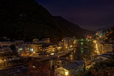 Illuminated cityscape against sky at night