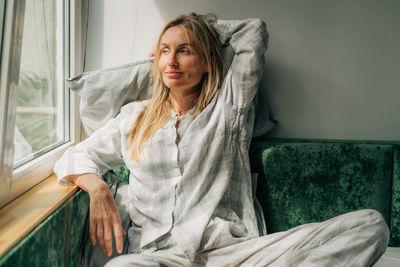 Young woman sitting on sofa at home