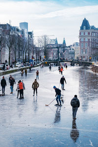 Group of people walking on frozen river in city