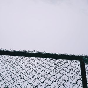 Low angle view of chainlink fence against clear sky