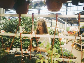Portrait of young woman looking at plants