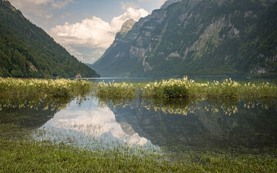 Scenic view of lake by mountains against sky