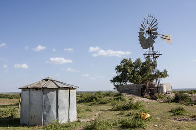 Traditional windmill on field against sky