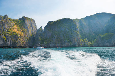 Scenic view of sea and mountains against sky