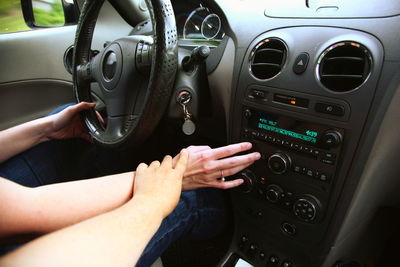 Women holding hands in car