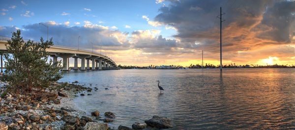 Bridge over river against sky during sunset