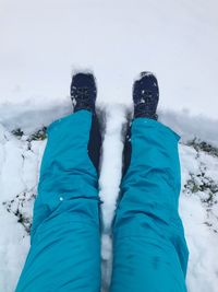 Low section of person standing on snow covered land