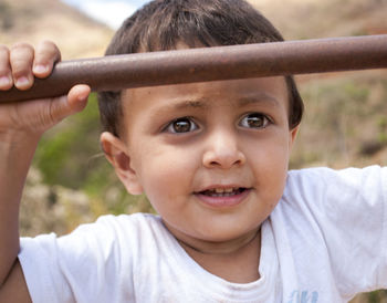 Close-up of cute baby boy holding metal pole