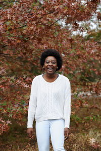 Portrait of smiling woman standing outdoors during autumn